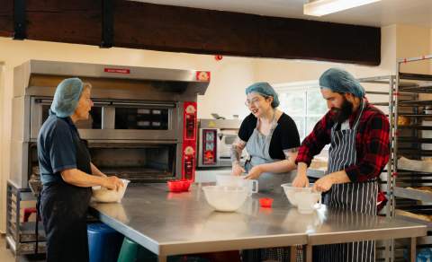 An instructor teaching visitors how to make bread at Side Oven Bakery