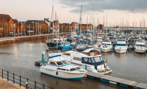 Hull Marina at sunset with rows of moored boats and yachts, historic waterfront buildings, and calm waters creating a scenic view of East Yorkshire’s popular harbour