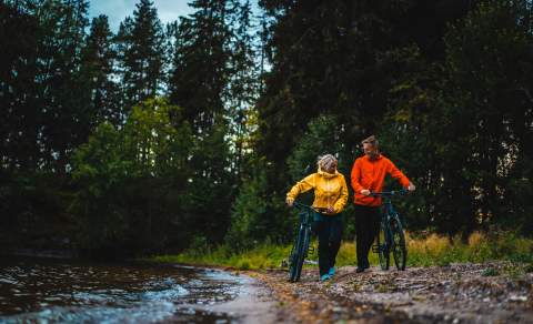 Mann og kvinne på sykkeltur ved stranda