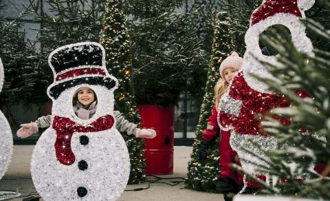 To jenter som leker ved julepynten på torget i Sarpsborg. Foto.