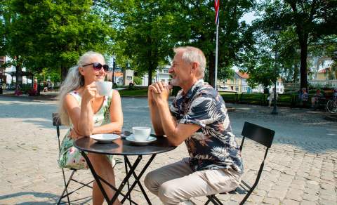 Par drikker kaffe på en fortauskafé i Halden