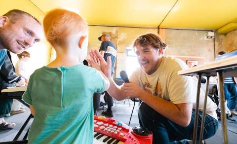 Musician and child high-fiving at Mosh Tots