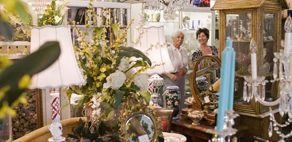 Two women in the background of a room with candles and lamps