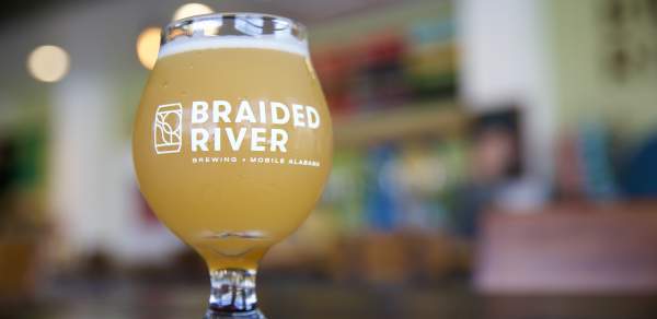 A glass of beer from Braided River Brewing Co sitting on a table