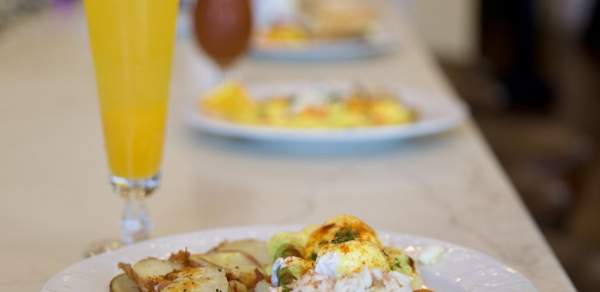Breakfast plate on a bar with a mimosa cocktail