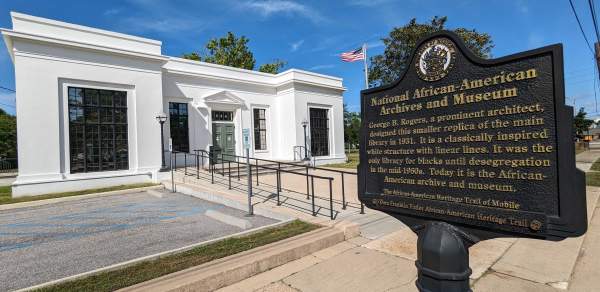 white building with an iron sign: National African American Archives and Museum