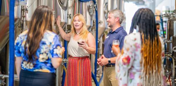 A woman guides a group through a brewery