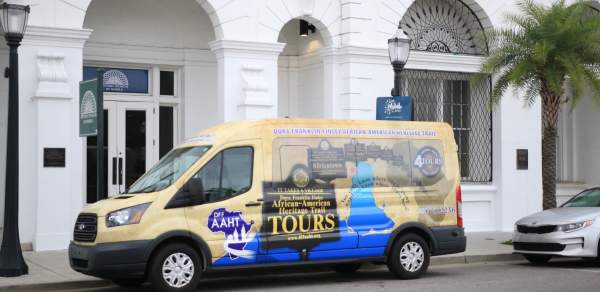 colorful passenger van parked in front of white building
