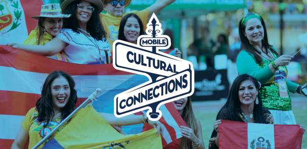 Latina women wearing brightly colored clothing and holding flags from their countries with Mobile Cultural Connections logo