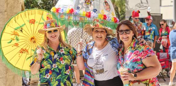 Group of women dressed in tropical clothes with umbrellas