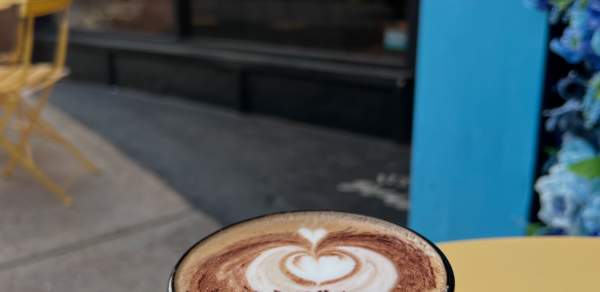 Mug of coffee sitting on a patio table outside