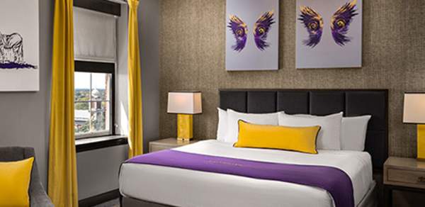 Hotel room bed, two framed artwork of wings above the bed