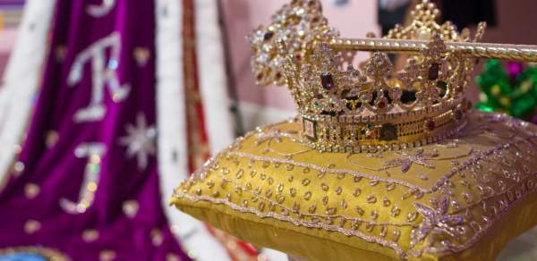 gold crown and scepter sitting on top of a gold pillow