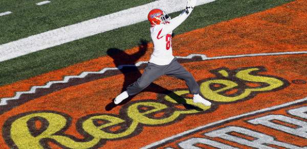 football player reaching to catch a football