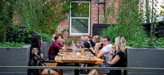 People dining on the back patio at The Wolf’s Tailor in Denver, Colorado.