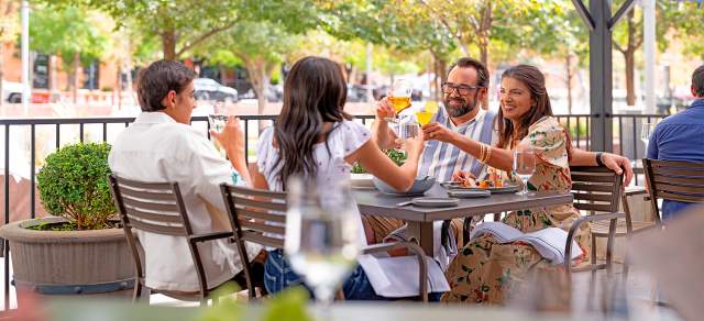 A group of people dine on the patio at Mercantile Dining & Provision in Denver, Colorado.