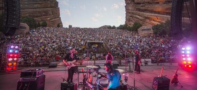 A band is playing at sunset at Red Rocks amphitheatre