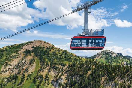 Snowbird's red tram with summer mountains in the background