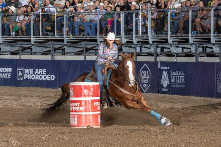 Brittney Pozzi Tonozzi in colorful shirt and cowboy hat barrel racing