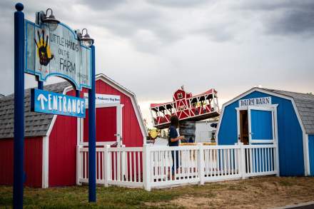 Two small barns, one red, one blue and a sign that says Little Hands on the Farm