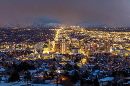 Aerial view of Salt Lake at night looking south down main street from above the capitol building. The city is lit up with yellow lights.