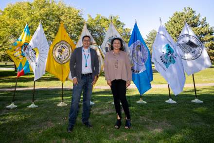 James Toledo and Dominique Talahaftewa of the Utah Division of Indian Affairs pose next to the flags from Utah’s eight original Tribal Nations.