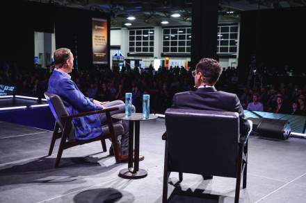 Two speakers on the main stage at a conference at the Salt Palace Convention Center.