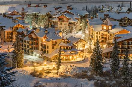 Aerial view of Solitude Village with snow on roofs and lit up with lights