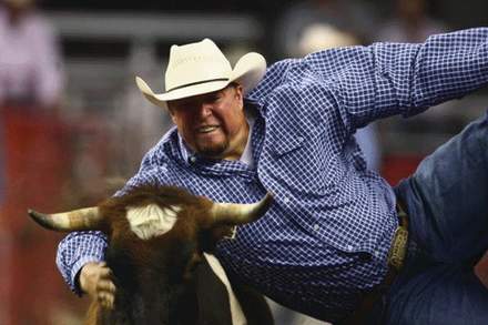 Man riding bull at Pioneer Day Rodeo