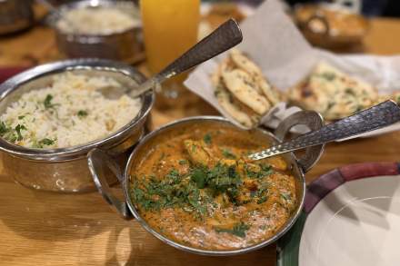 A table with pots of curry and rice at Mumbai House.