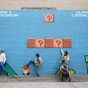 family interacting with mario mural
