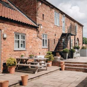 Accommodation exterior with picnic benches and plants