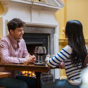 A couple enjoying a glass of wine at a dinner table