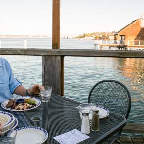 Man Sitting w/ food at a Water View