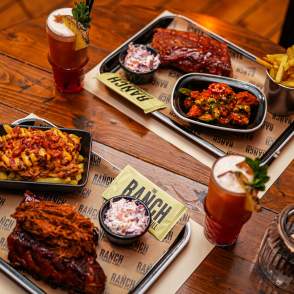 a table with barbeque meals and drinks