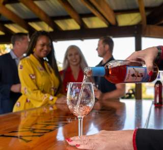 Friends relaxing at Duplin Winery as the bartender pours a rose wine