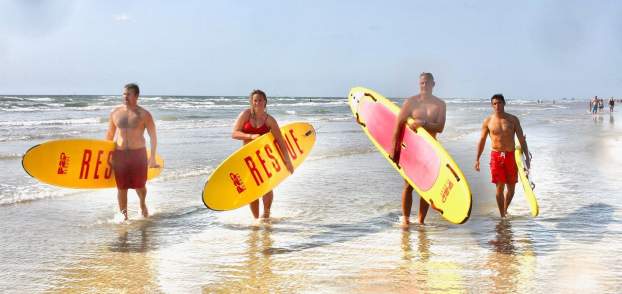 Port Aransas lifeguards hold surfboards in the surf