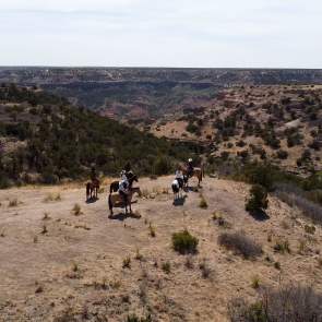 Group of people riding horseback in Los Cedros Ranch