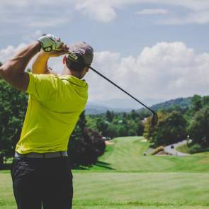 Man taking a golf swing at a golf course in Beaumont, TX