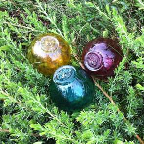 colored glass floats on pine branches