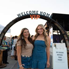 Two Girls posing infrom of the VIP entrance to the Feels Like Home Festival
