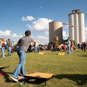 image of kids playing cornhole on the reunion lawn at the Feels like home festival on a sunny day.