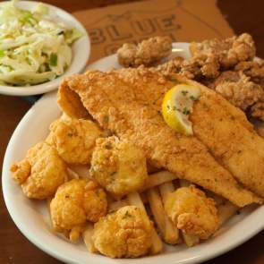 A large plate of fried seafood and a bowl of cole slaw