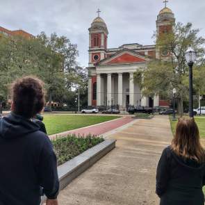 People walking in Cathedral Square facing the Cathedral-Basilica of the Immaculate Conception