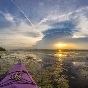 View of sunset over the water from a kayak