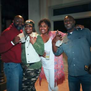 four people hugging and smiling