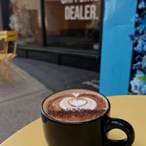 Mug of coffee sitting on a patio table outside