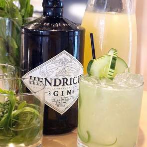 two cocktails and a gin bottle