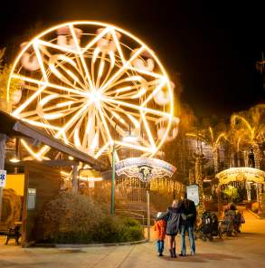 Family looking at the Panoramic Wheel lit up at Gilroy Gardens