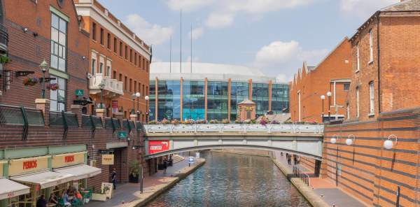 A view down the canal, on a sunny day, of the Utilita Arena Birmingham